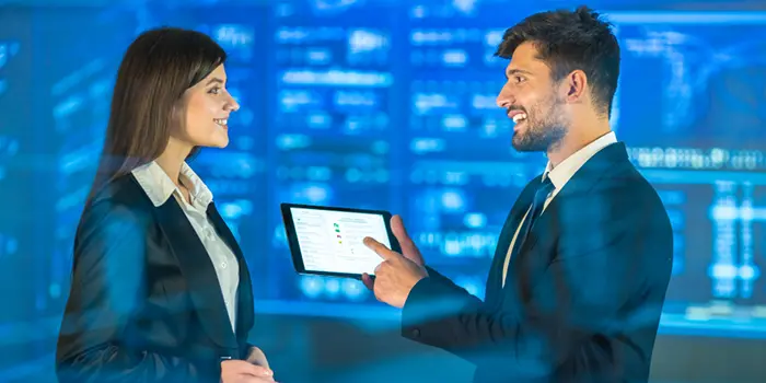 how to choose right sap partner A man and woman in business attire examine a tablet, symbolizing collaboration in selecting the right SAP partner.